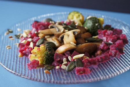 glutenfreier Randensalat mit gebratenen Pilzen, schön serviert auf einem Glasteller